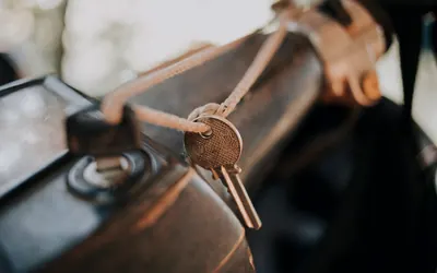 Motorradschlüssel an einem Lederband am Tank eines Motorrads