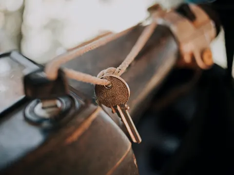 Motorradschlüssel an einem Lederband am Tank eines Motorrads
